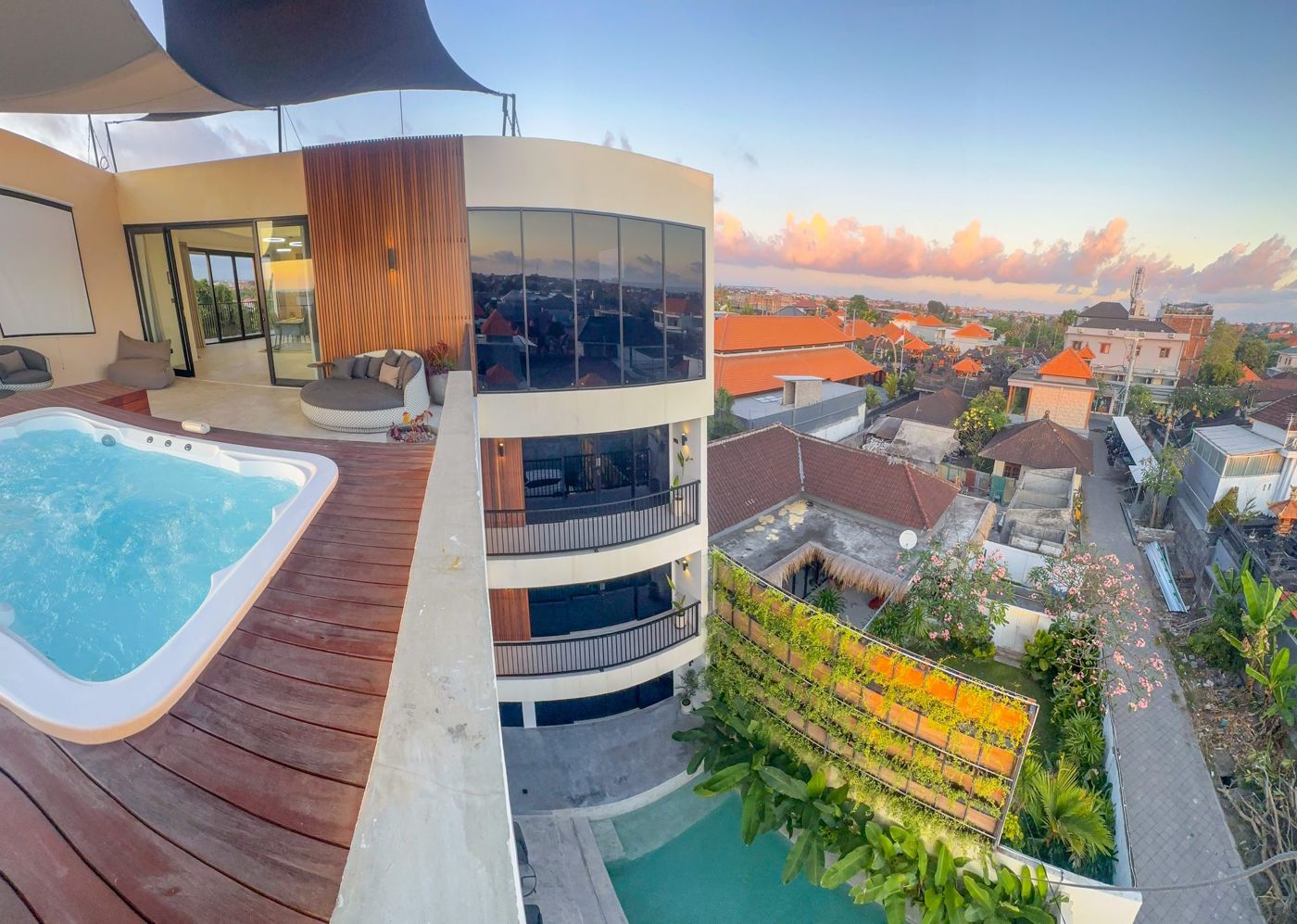 Rooftop jacuzzi deck at sunset, pool and garden below